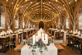 Salle de mariage d'hiver décorée de guirlandes lumineuses, bougies et branches de bouleau pour une ambiance féerique