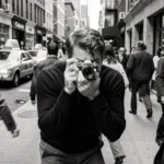 Photographe de rue dans le style de William Klein, angle rapproché agressif sur un trottoir animé de New York en noir et blanc