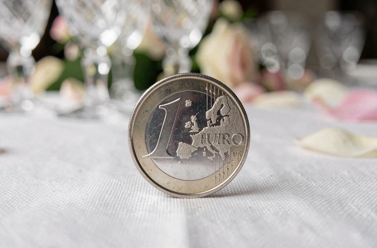 Pièce de monnaie en euro posée sur une nappe blanche de table de réception de mariage